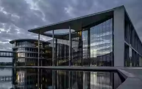Moderne Glas- und Stahlfassade eines Behördengebäudes bei Dämmerung, Architekturaufnahme ohne Text. - Foto: über boerse-global.de