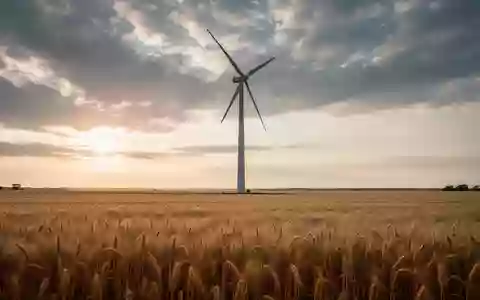 Ein modernes Windrad in einem sonnendurchfluteten Weizenfeld bei Sonnenuntergang. - Foto: über boerse-global.de