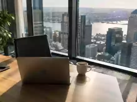 Ein minimalistischer, sonnendurchfluteter Büroarbeitsplatz in einem Finanzviertel mit Fokus auf eine ruhige, professionelle Atmosphäre. - Foto: über boerse-global.de