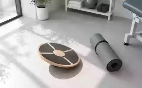 Ein minimalistisch eingerichteter Physiotherapieraum mit einem Balance-Board und einer Sportmatte auf einem hellen Boden. - Foto: über boerse-global.de