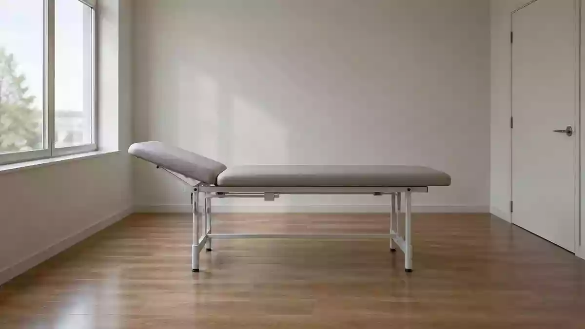 Ein leerer medizinischer Untersuchungstisch in einem minimalistischen, hellen Behandlungsraum mit natürlichem Tageslicht. Illustration mit AI erstellt.
