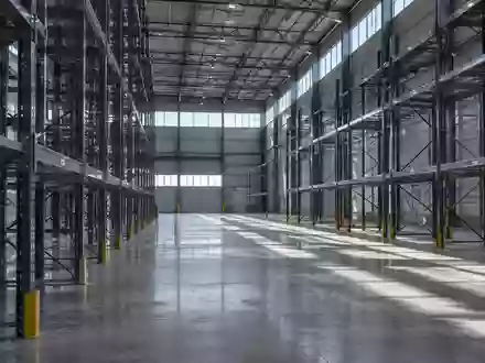 Weitläufiges, modernes Industrielager mit Betonboden und Stahlregalen in natürlichem Licht. - Foto: über boerse-global.de