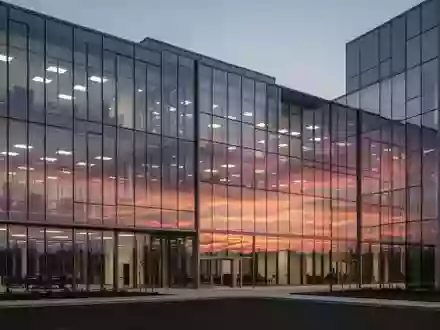 Ein modernes Bürogebäude aus Glas in der Abenddämmerung, das den Sonnenuntergang reflektiert. - Foto: über boerse-global.de