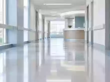 Ein leerer, modern gestalteter Krankenhausflur mit indirekter Beleuchtung und minimalistischer Architektur. - Foto: über boerse-global.de