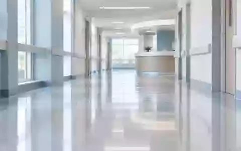 Ein leerer, modern gestalteter Krankenhausflur mit indirekter Beleuchtung und minimalistischer Architektur. - Foto: über boerse-global.de