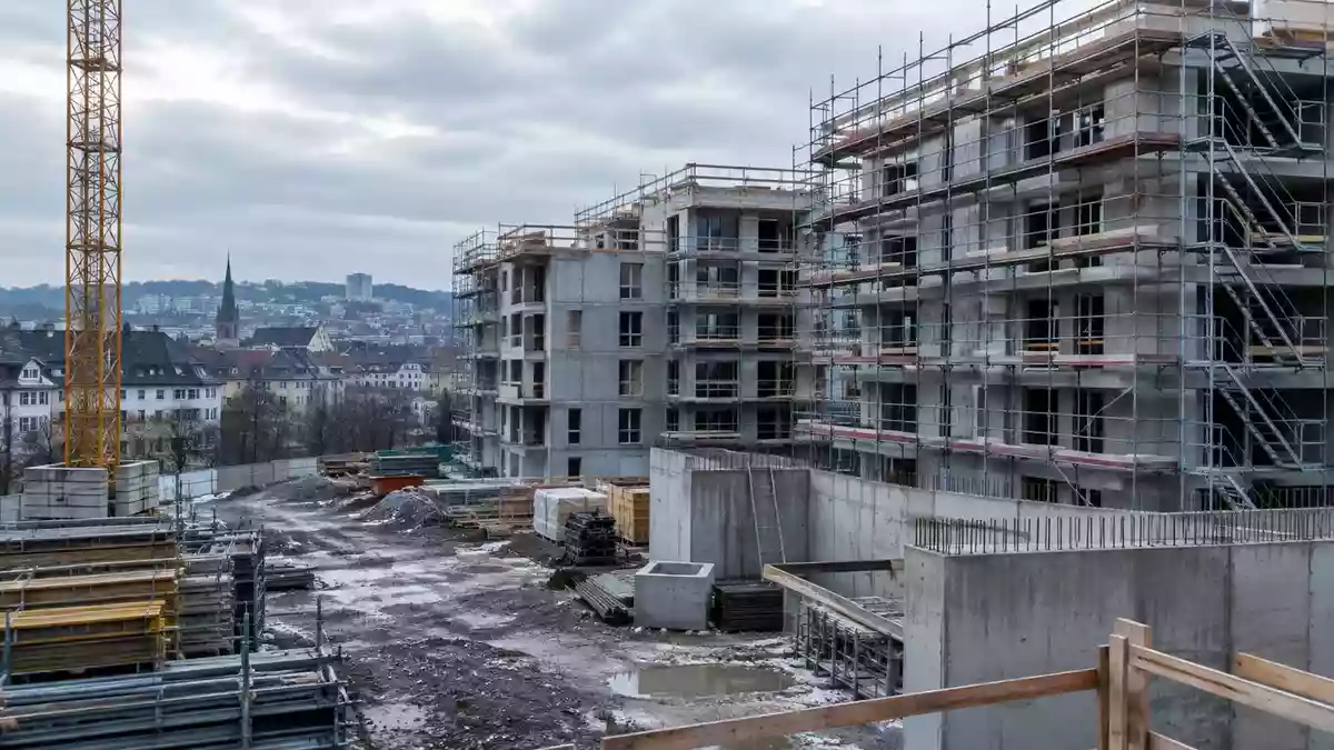 Halbfertige Wohnbaustelle im europäischen Stadtgebiet mit Gerüsten und Betonstrukturen bei bedecktem Himmel. Illustration mit AI erstellt.