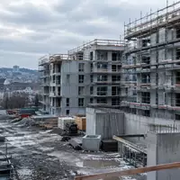 Halbfertige Wohnbaustelle im europäischen Stadtgebiet mit Gerüsten und Betonstrukturen bei bedecktem Himmel. - Foto: über boerse-global.de