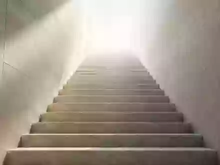 Eine minimalistische Steintreppe, die in helles Licht führt und Ordnung sowie eine klare Hierarchie symbolisiert. - Foto: über boerse-global.de