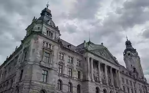 Fassade eines historischen Verwaltungsgebäudes in Leipzig unter einem bewölkten Himmel. - Foto: über boerse-global.de