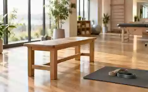 Ein heller, minimalistischer Trainingsraum mit einer leeren Holzbank und elastischen Bändern auf einer Matte. - Foto: über boerse-global.de