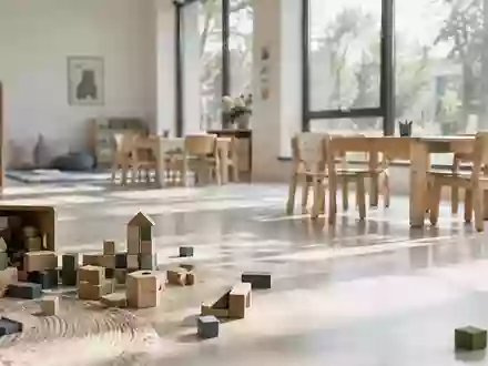 Ein leerer Gruppenraum in einer Kindertagesstätte mit hölzernem Spielzeug und kleinen Stühlen im sanften Tageslicht. - Foto: über boerse-global.de