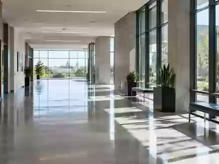 Ein heller, minimalistischer Flur in einem modernen Verwaltungsgebäude mit poliertem Betonboden und großen Fensterfronten. - Foto: über boerse-global.de