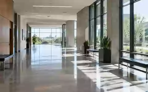 Ein heller, minimalistischer Flur in einem modernen Verwaltungsgebäude mit poliertem Betonboden und großen Fensterfronten. - Foto: über boerse-global.de