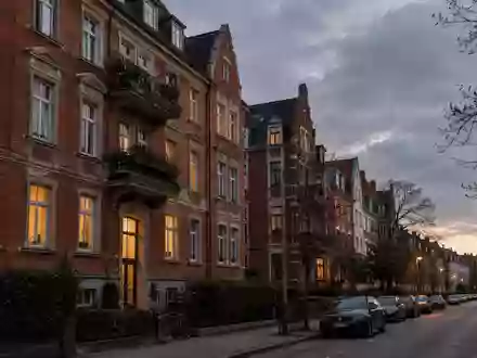 Wohngebäude in einer deutschen Stadt bei Dämmerung mit beleuchteten Fenstern und klassischer Fassade. - Foto: über boerse-global.de
