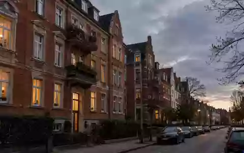 Wohngebäude in einer deutschen Stadt bei Dämmerung mit beleuchteten Fenstern und klassischer Fassade. - Foto: über boerse-global.de