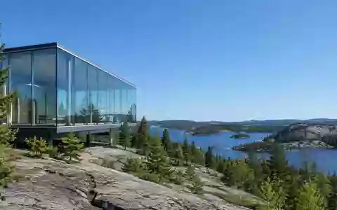 Moderne Glas- und Stahlarchitektur vor einer weiten kanadischen Wald- und Felslandschaft. - Foto: über boerse-global.de