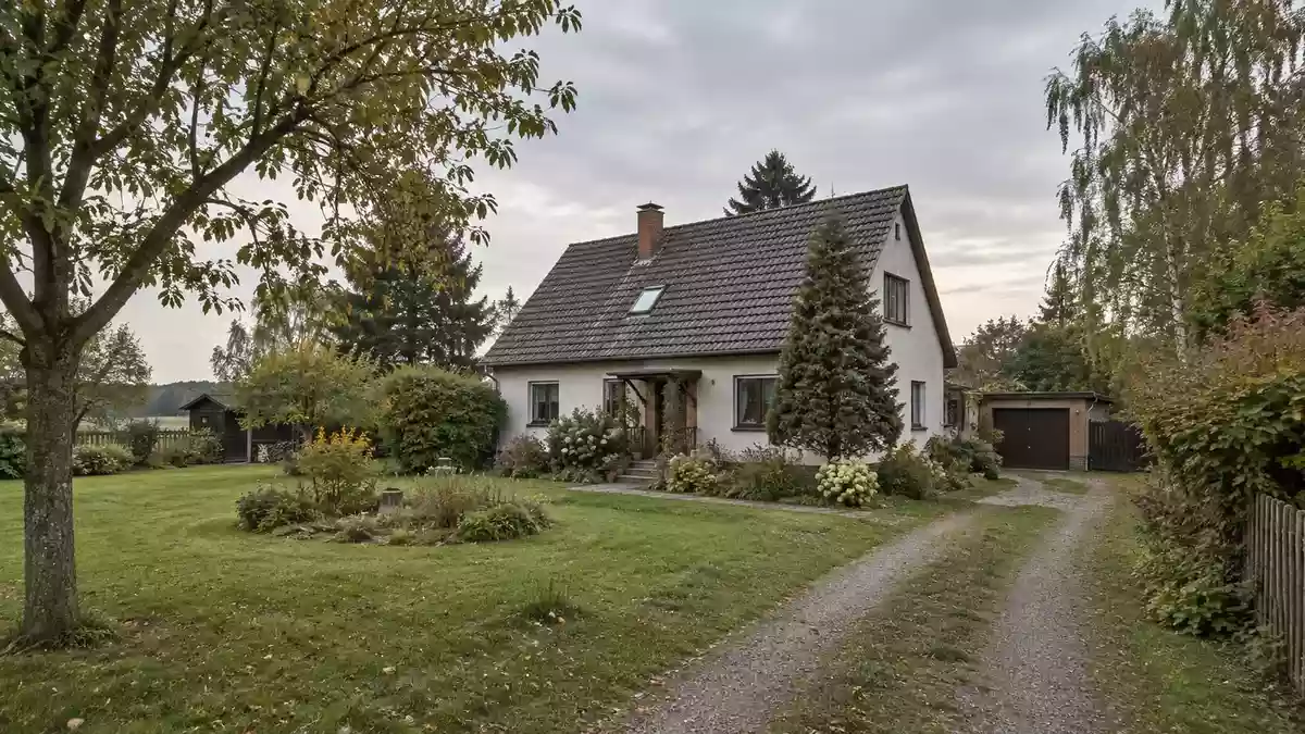 Ein Wohnhaus in einer ländlichen Umgebung in Brandenburg mit einem weitläufigen Garten bei bewölktem Tageslicht. Illustration mit AI erstellt.