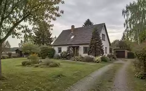 Ein Wohnhaus in einer ländlichen Umgebung in Brandenburg mit einem weitläufigen Garten bei bewölktem Tageslicht. - Foto: über boerse-global.de
