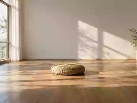 Ein minimalistischer, ruhiger Raum mit einem einzelnen Meditationskissen auf einem Holzboden und einfallendem Sonnenlicht. - Foto: über boerse-global.de