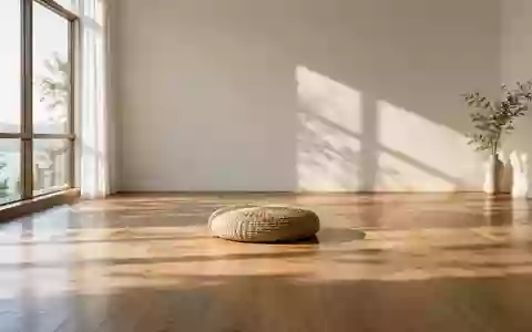 Ein minimalistischer, ruhiger Raum mit einem einzelnen Meditationskissen auf einem Holzboden und einfallendem Sonnenlicht. - Foto: über boerse-global.de
