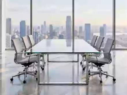 Ein heller, leerer Konferenzraum in einem modernen Bürogebäude mit großen Fenstern und Blick auf eine Stadtkulisse. - Foto: über boerse-global.de