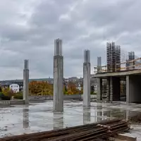 Rohbau eines modernen Wohngebäudes auf einer Baustelle bei bewölktem Himmel. - Foto: über boerse-global.de