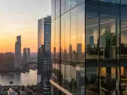 Moderne Glasfassade eines Bürogebäudes in einem Finanzviertel bei Sonnenuntergang. - Foto: über boerse-global.de