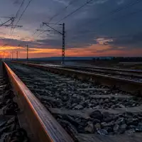 Leere Bahngleise bei Dämmerung mit Oberleitungen im Hintergrund. - Foto: über boerse-global.de