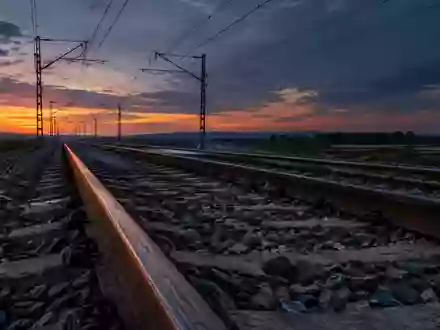 Leere Bahngleise bei Dämmerung mit Oberleitungen im Hintergrund. - Foto: über boerse-global.de