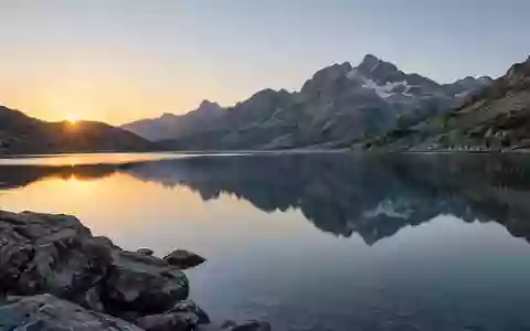 Ein ruhiger Bergsee bei Tagesanbruch, der Stille und innere Ausgeglichenheit symbolisiert. - Foto: über boerse-global.de