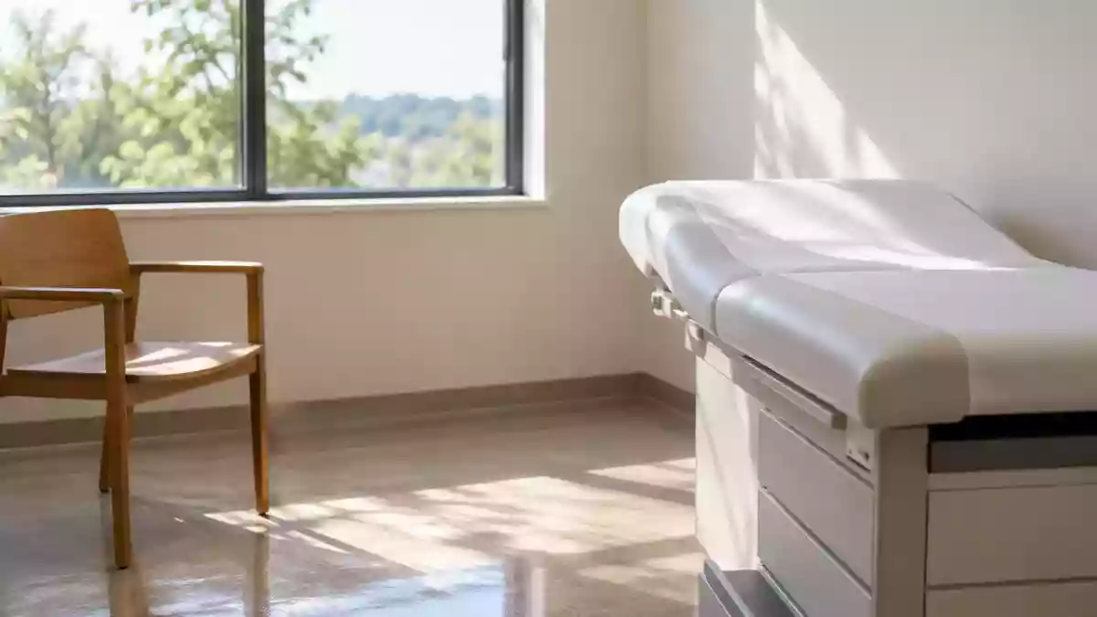 Ein heller, minimalistischer Behandlungsraum in einer orthopädischen Praxis mit einer leeren Untersuchungsliege. Illustration mit AI erstellt.