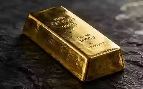 Ein einzelner Goldbarren auf einer dunklen Schieferplatte bei gedimmtem, natürlichem Licht. - Foto: über boerse-global.de