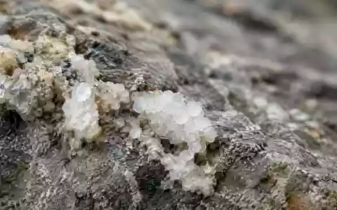 Nahaufnahme von mineralischen Ablagerungen auf einer Gesteinsoberfläche mit natürlicher Textur. - Foto: über boerse-global.de
