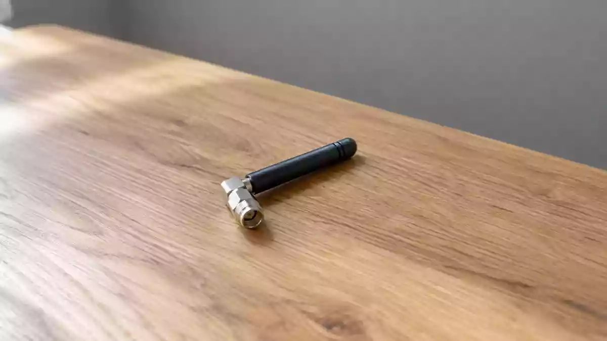 Ein minimalistischer Arbeitsbereich mit einer kleinen Antennenkomponente auf einer Holzoberfläche bei natürlichem Licht. Illustration mit AI erstellt.