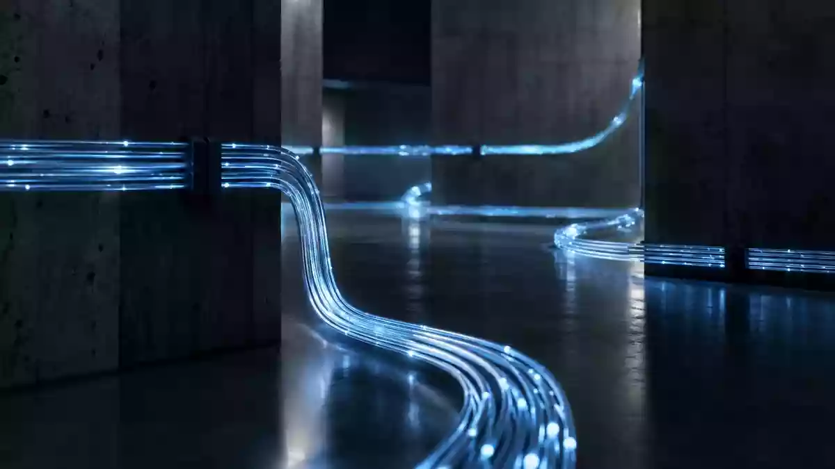 Abstrakte Darstellung von Glasfaserkabeln in einer dunklen, industriellen Umgebung als Symbol für digitale Analyseprozesse. Illustration mit AI erstellt.