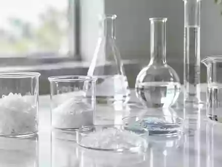 LaborausrĂĽstung mit Glasbechern und wissenschaftlichen Utensilien in einer hellen, minimalistischen Umgebung. - Foto: ĂĽber boerse-global.de