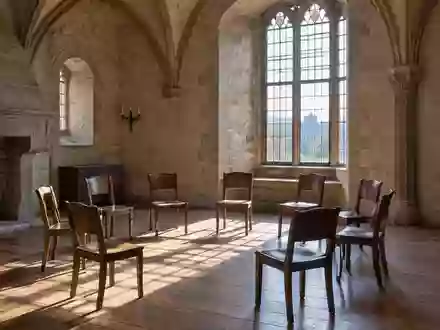 Ein heller, leerer Veranstaltungsraum mit Stuhlreihen in einem historischen Schlossgebäude. - Foto: über boerse-global.de