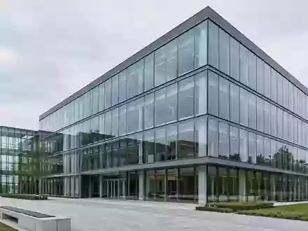 Moderne Glas- und Stahlfassade eines Bürogebäudes bei bewölktem Himmel. - Foto: über boerse-global.de