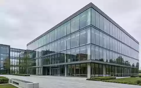 Moderne Glas- und Stahlfassade eines Bürogebäudes bei bewölktem Himmel. - Foto: über boerse-global.de