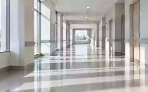 Ein leerer, ruhig beleuchteter Krankenhausflur mit klaren Linien und minimalistischer Architektur. - Foto: über boerse-global.de