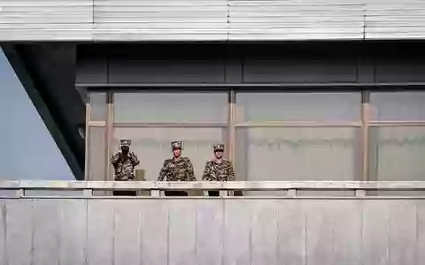 Nordkoreanische Soldaten beobachten Merz. - Foto: Kay Nietfeld/dpa