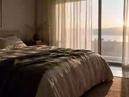 Ein minimalistisches, ruhiges Schlafzimmer bei Tagesanbruch, das eine Atmosphäre der Entspannung und Erholung vermittelt. - Foto: über boerse-global.de