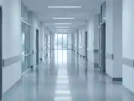 Ein minimalistischer, steriler Krankenhausflur in kühlem Licht mit Fokus auf die architektonische Tiefe. - Foto: über boerse-global.de