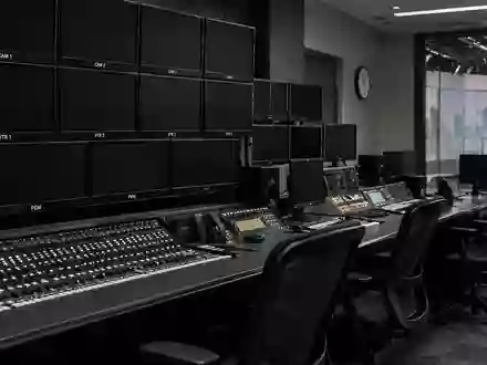 Dunkle, inaktive Monitore und professionelle Audiotechnik in einem modernen Fernseh-Regieraum. - Foto: über boerse-global.de