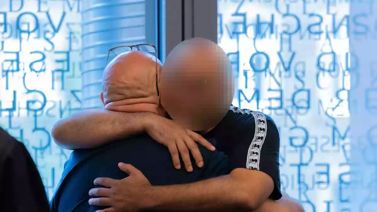 Der Hauptangeklagte (links) und ein Angeklagter umarmen sich in einem Gerichtssaal im Justizzentrum. (Archivbild) - Bild: Rolf Vennenbernd/dpa