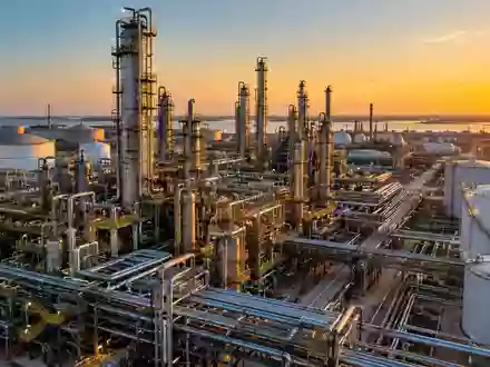 Moderne petrochemische Industrieanlage bei Sonnenuntergang mit komplexen Rohrleitungen und Destillationstürmen. - Foto: über boerse-global.de