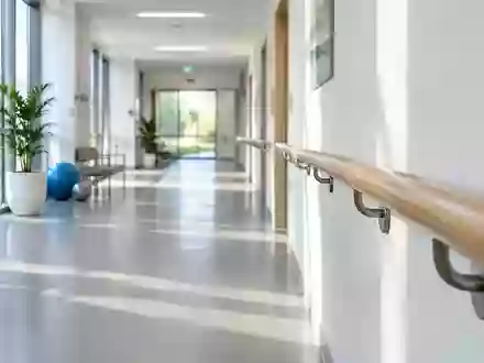 Ein heller, minimalistischer Flur in einer medizinischen Einrichtung mit einem hölzernen Handlauf an der Wand. - Foto: über boerse-global.de