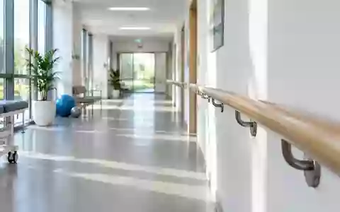 Ein heller, minimalistischer Flur in einer medizinischen Einrichtung mit einem hölzernen Handlauf an der Wand. - Foto: über boerse-global.de