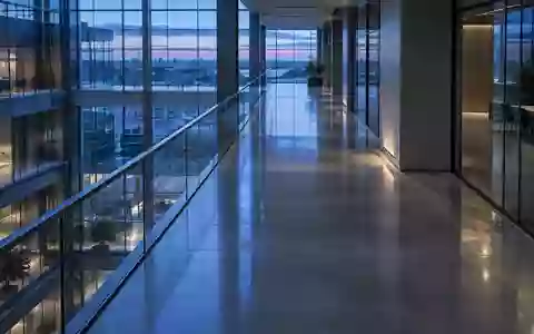 Ein minimalistischer, leerer Büroflur in einem modernen Gebäude mit kühlem, blauem Licht und klaren architektonischen Linien. - Foto: über boerse-global.de