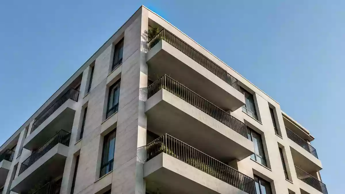 Fassade eines mehrstöckigen Wohngebäudes mit geometrischen Balkonen bei Tageslicht. Illustration mit AI erstellt.